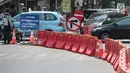 Petugas mengatur lalu lintas saat uji coba sistem satu arah di Jalan KH Wahid Hasyim, Jakarta, Selasa (9/10). Dalam uji coba tersebut, kendaraan dari arah Jalan Agus Salim dilarang berbelok menuju Jalan KH Wahid Hasyim. (Liputan6.com/Faizal Fanani)