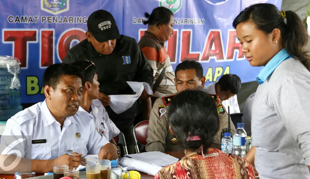 Petugas mengecek kelengkapan data surat dan Kartu Keluarga (KK) yang mendaftarkan diri untuk menerima jatah rumah susun, Jakarta, Rabu (30/3). Sebanyak 310 rumah yang berada di pasar ikan akan dibongkar pemprov DKI Jakarta. (Liputan6.com/Yoppy Renato)