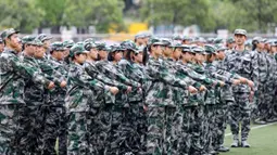 Murid sekolah menengah mengambil bagian dalam sesi pendidikan dan pelatihan militer pada awal semester baru di Huaibei, Provinsi Anhui, China, 5 September 2021. (STR/AFP)
