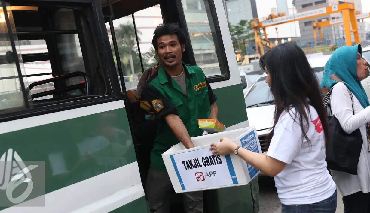 Kondektur mengambil takjil gratis yang dibagikan oleh Karyawan Asia Pulp & Paper (APP) Sinar Mas di kawasan Bundaran HI, Jakarta (24/6). (Liputan6.com/ Immanuel Antonius)
