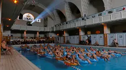 Pengunjung serius menonton bioskop sambil bersantai di kolam renang pemandian umum Strasbourg selama European Fantastic Film Festival di Strasbourg, Prancis, Minggu (18/9). (REUTERS/Vincent Kessler)