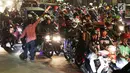 Seorang pria mengatur arus lalu lintas pemudik bersepeda motor di ruas Kalimalang, Bekasi, Kamis (22/6). Pada malam hari peningkatan kendaraan pemudik terutama yang menggunakan roda dua jauh lebih tinggi dibanding siang hari. (Liputan6.com/Angga Yuniar)