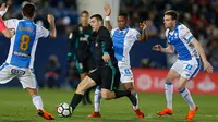 Pemain Real Madrid, Mateo Kovacic mengendalikan bola dengan kawalan pemain Leganes pada partai tunda pekan ke-16 La Liga Spanyol di Estadio Municipal de Butarque, Rabu (21/2). Madrid menang 3-1 atas Leganes meski sempat ketinggalan. (AP/Francisco Seco)