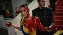 Perempuan itu muncul di karpet merah bersama A-listers dengan gaun biru dan kuning sepanjang lantai. (AP Photo/Daniel Cole)