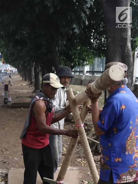 Penjual sedang mengerjakan pohon pinang yang akan dijual di kawasan Tanjung Barat, Jakarta, Kamis (8/8). Penjualan pohon Pinang untuk perlombaan panjat pinang memeriahkan peringatan HUT Kemerdekaan RI tersebut mulai marak. (Liputan6.com/Herman Zakharia)
