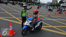 Petugas memberi petunjuk kepada pengendara motor saat pengalihan arus di kawasan Sarinah, Jakarta, Jumat (4/11). Pengalihan arus lalu lintas ini disebabkan karena beberapa titik jalan tidak bisa digunakan akibat aksi massa. (Liputan6.com/Angga Yuniar)