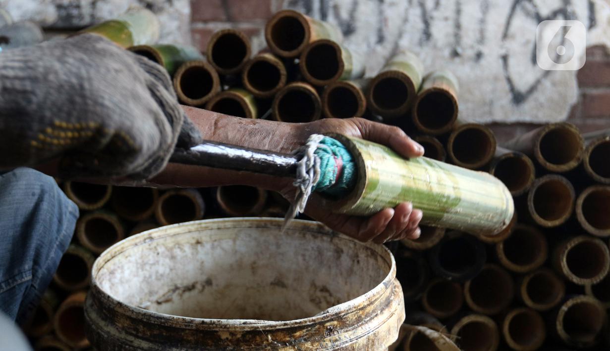 Pekerja membuat lemang bambu di Jalan Kramat Raya, Senen, Jakarta Pusat, Rabu (6/4/2022). Makanan khas Sumatera Barat yang cocok dijadikan sebagai menu berbuka puasa tersebut dijual dengan harga Rp 15.000 - Rp 30.000. (Liputan6.com/Herman Zakharia)