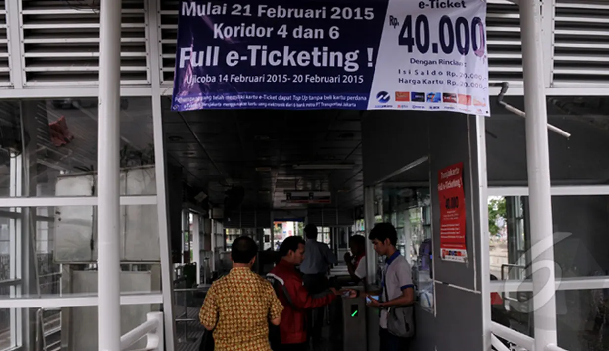  Petugas saat melayani pengguna bus Transjakarta yang mengunakan e-ticketing, Jakarta, Sabtu (21/2/2015). PT Transportasi Jakarta (Transjakarta) menyatakan seluruh 12 koridor Transjakarta resmi menggunakan e-ticketing. (Liputan6.com/JohanTallo)