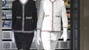 Aksi robot super fashionable yang mengenakan rancangan desainer Karl Lagerfeld untuk koleksi musim semi 2017 di Paris Fashion Week, Prancis, Selasa (4/10). Keduanya memakai setelan klasik Chanel dengan warna hitam dan putih. (REUTERS/Charles Platiau)