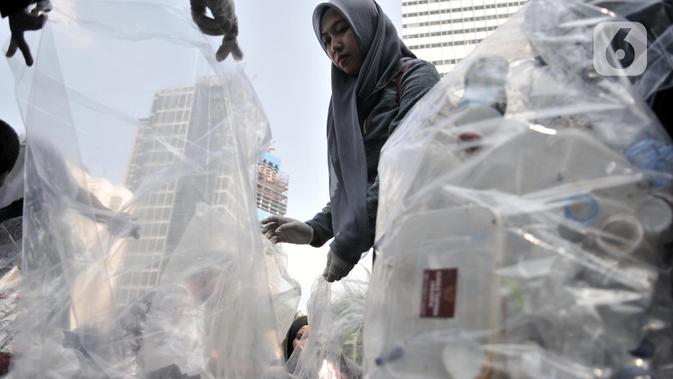 Aktivis yang tergabung dalam Sekolah Relawan memunguti sampah saat aksi Jakarta Clean Action selama Hari Bebas Kendaraan Bermotor (HBKB) di kawasan Bundaran HI, Jakarta, Minggu (1/12/2019). (merdeka.com/Iqbal S. Nugroho)