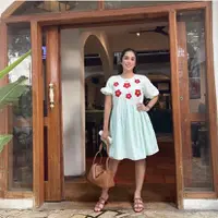 Ussy mengenakan dress selutut warna baby blue dengan detail bunga merah di bagian depan. Detail lengan model  Balloon membuat Ussy tampak muda. Tampilannya terlihat santai dengan mengenakan sandal dan handbag.  (Dok. Instagram @ussypratama)