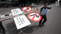 Petugas Dishub DKI mengangkut rambu larangan sepeda motor melintasi Jalan MH Thamrin, Jakarta Pusat, Rabu (10/1). Dishub DKI Jakarta telah berkoordinasi dengan Dirlantas dan Bina Marga terkait pencopotan. (Liputan6.com/Arya Manggala)