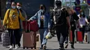 Wisatawan mengenakan masker wajah dengan barang bawaan mereka meninggalkan stasiun kereta api Beijing di Beijing, Selasa (6/9/2022). China lockdown jutaan warganya di bawah pembatasan ketat COVID-19. (AP Photo/Andy Wong)