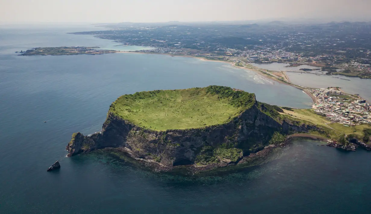 Pemandangan udara Seongsan Ilchulbong, atau 'Puncak Matahari Terbit', formasi batuan vulkanik di pulau Jeju, Korea Selatan (10/5/2019). Pulau Jeju adalah pulau terbesar di Korea dan terletak di sebelah selatan Semenanjung Korea. (AFP Photo/Ed Jones)