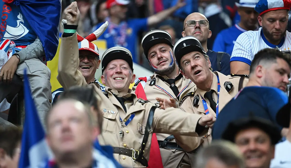 Pendukung Prancis yang berpakaian seperti petugas gendarme menghadiri pertandingan sepak bola Euro 2024 Grup D antara Austria dan Prancis di Duesseldorf Arena, Duesseldorf pada 17 Juni 2024. (OZAN KOSE/AFP)