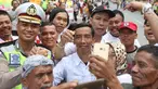 Seorang pria berwajah mirip Presiden Joko Widodo (Jokowi) berswafoto bersama warga yang memadati sekitar Gedung Graha Saba Buana, Solo, Rabu (8/11). Pria bernama David itu beberapa saat berhasil mengecoh warga. (Liputan6.com/Angga Yuniar)
