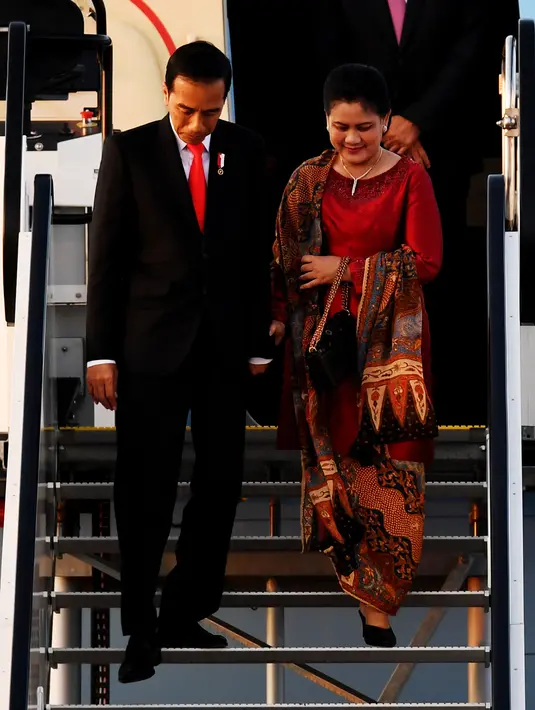 Presiden RI, Joko Widodo (Jokowi) bersama Ibu Negara, Iriana Joko Widodo, turun dari pesawat setibanya di Hamburg, Jerman, Kamis (6/7). Sejumlah kepala negara telah tiba di Hamburg jelang pembukaan KTT G20 pada 7-8 Juli 2017.  (PATRIK STOLLARZ / AFP)