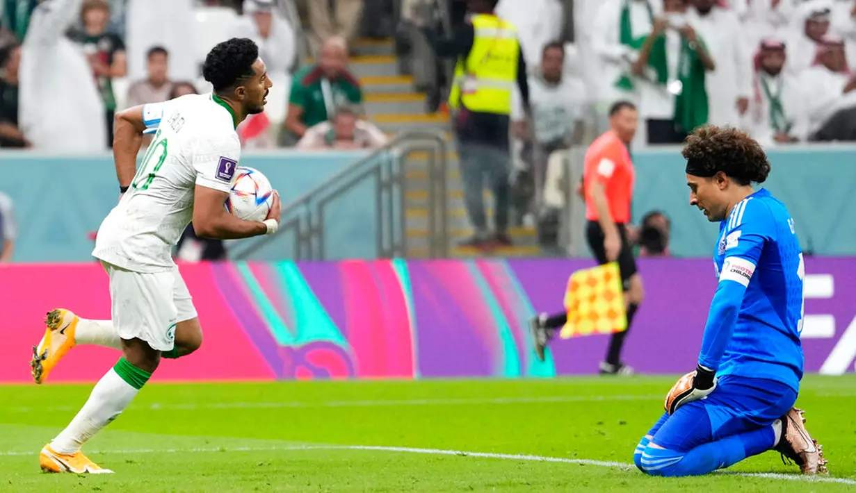 Pemain Arab Saudi Salem Al-Dawsari (kiri) berlari melewati kiper Meksiko Guillermo Ochoa usai mencetak gol pada pertandingan sepak bola Grup C Piala Dunia 2022 di Stadion Lusail, Lusail, Qatar, 30 November 2022. Meksiko menang 2-1 tetapi gagal melaju ke babak 16 besar Piala Dunia 2022. (AP Photo/Manu Fernandez)