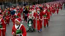 Orang-orang mengenakan kostum Sinterklas mengambil bagian dalam Santa Claus Run di Madrid, Spanyol, Minggu (9/12). Ribuan memeriahkan acara yang sudah diselenggarakan sejak 7 tahun yang lalu. (AP/Emilio Morenatti)