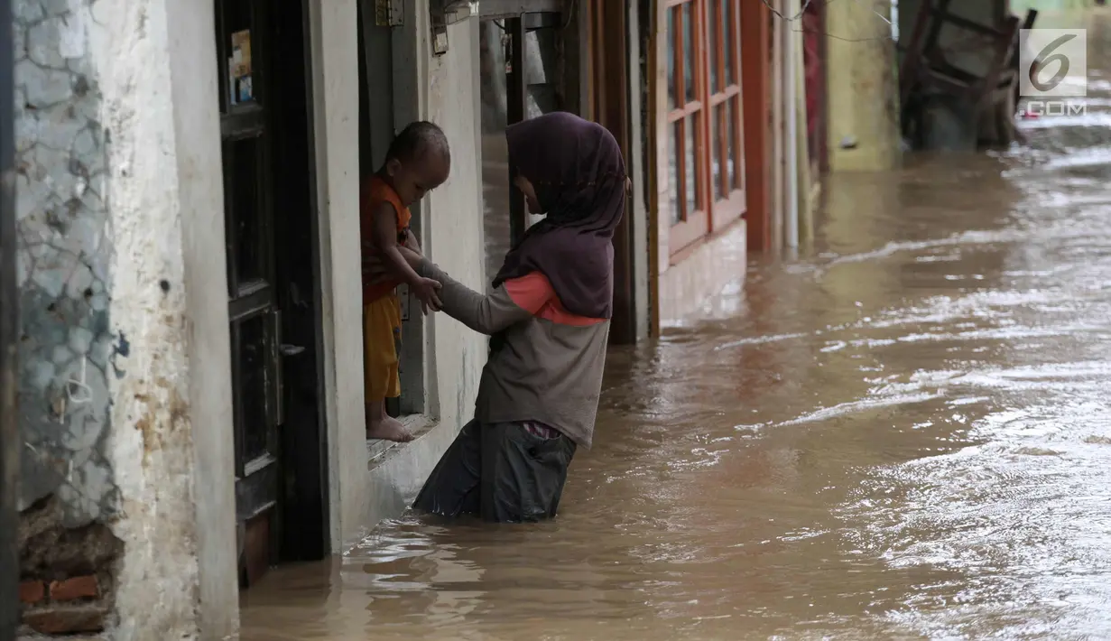 Warga beraktivitas saat banjir di Jalan Kebon Pala, Kampung Melayu, Jatinegara, Jakarta Timur, Rabu (7/2). Setelah sempat surut, banjir kembali merendam permukiman warga dengan ketinggian air mencapai sekitar 170 cm. (Liputan6.com/Arya Manggala)