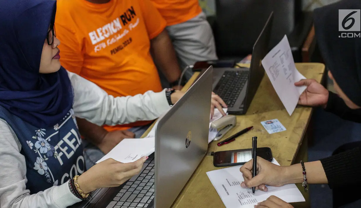 Petugas membantu warga yang mengurus formulir A5 atau surat pindah memilih di Kantor KPU Kota Jakarta Pusat, Minggu (17/2). Tahap kedua pelayanan pindah memilih berlangsung hingga 16 Maret 2019. (Liputan6.com/Faizal Fanani)