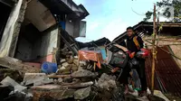 Warga melewati puing bangunan rumah yang rusak akibat gempa berkekuatan magnitudo 5,6 di kawasan Cibeureum, Cianjur, Jawa Barat, Selasa (22/11/2022). Sebanyak 94 orang meninggal dunia dan 30 orang lainnya dinyatakan hilang usai terjadinya gempa bumi merusak berkekuatan M 5.6 di Kabupaten Cianjur pada Senin kemarin. (merdeka.com/Arie Basuki)