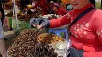 Dengan minyak goreng panas, tarantula yang sudah dibersihkan ini digoreng hingga garing dan diberi bawang putih (AFP)