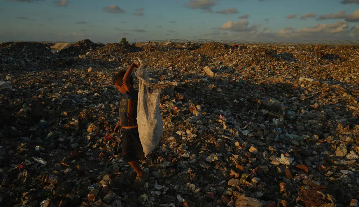 Seorang anak Palestina yang mengungsi mencari kayu bakar dan plastik di tempat pembuangan sampah di samping kamp tenda darurat tempat keluarganya berlindung, di Khan Younis, Jalur Gaza selatan, Selasa 30 September 2025. (AP Photo/Jehad Alshrafi)