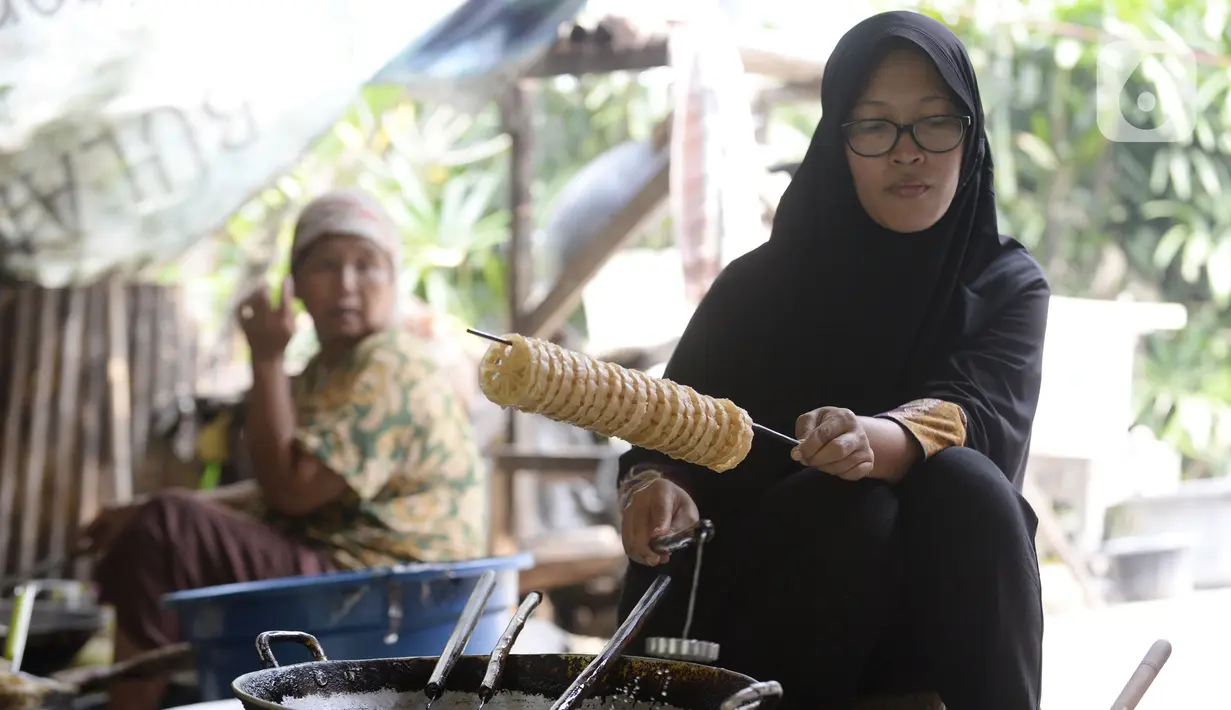 Pekerja menggoreng jajanan tradisional kembang goyang di Kelurahan Karangan, Setu, Tangerang Selatan, Banten, Kamis (6/8/2020). Jajanan kue kering berbentuk bunga tersebut dijual dengan harga Rp 5 ribu per bungkus. (merdeka.com/Dwi Narwoko)