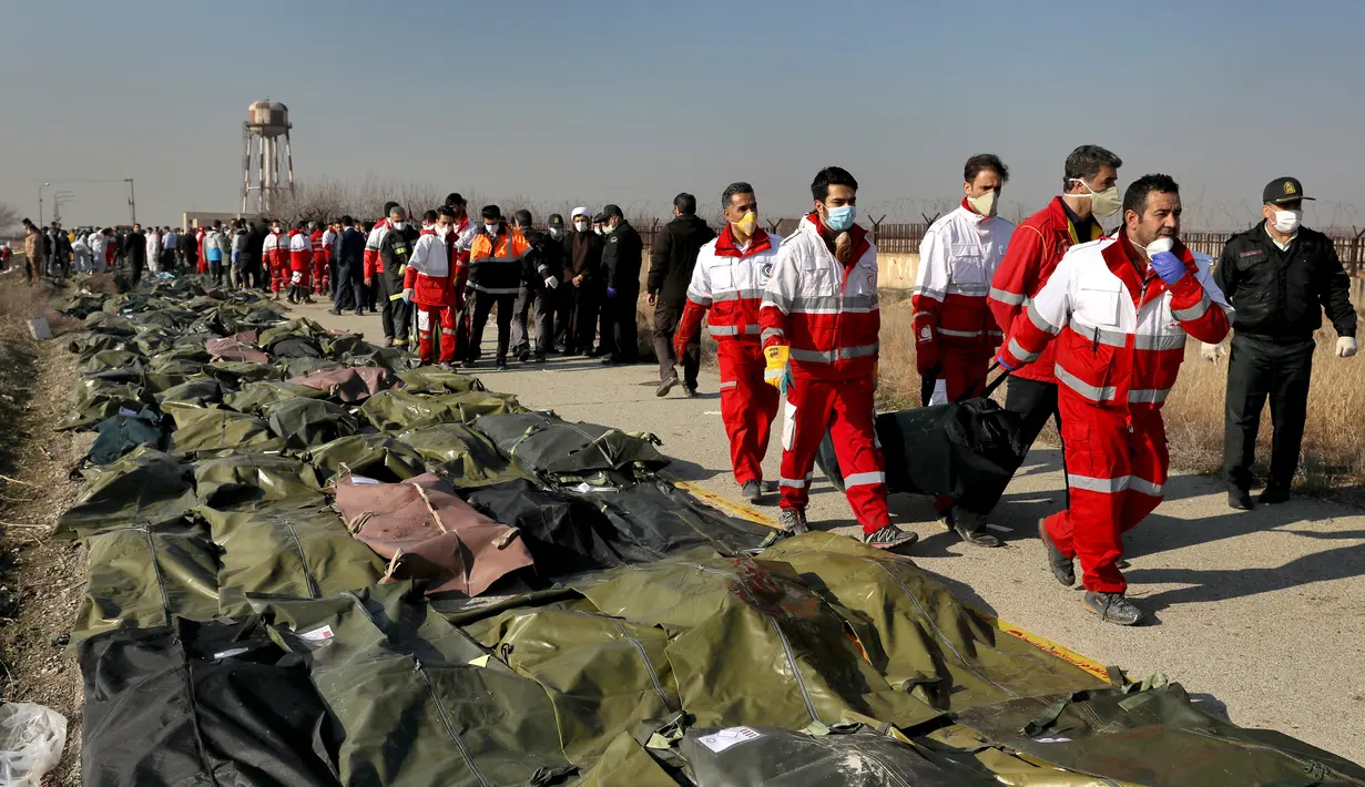 Tim penyelamat mengumpulkan jasad korban jatuhnya pesawat Boeing 737-800 di Shahedshahr, Iran, Rabu (8/1/2020). Sebanyak 176 orang dalam pesawat maskapai penerbangan Ukraine International Airlines tersebut dipastikan tewas. (AP Photo/Ebrahim Noroozi)
