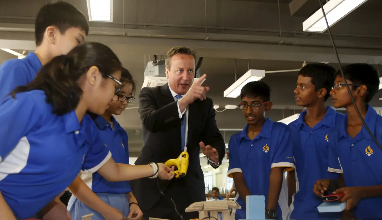 Perdana Menteri Inggris David Cameron berbaur dengan para siswa di Sekolah Menengah Commonwealth, Singapura, Rabu (29/7/2015).  PM Inggris David Cameron adalah sosok yang ramah dan bisa berbaur dengan siapa saja. (REUTERS/Edgar Su)