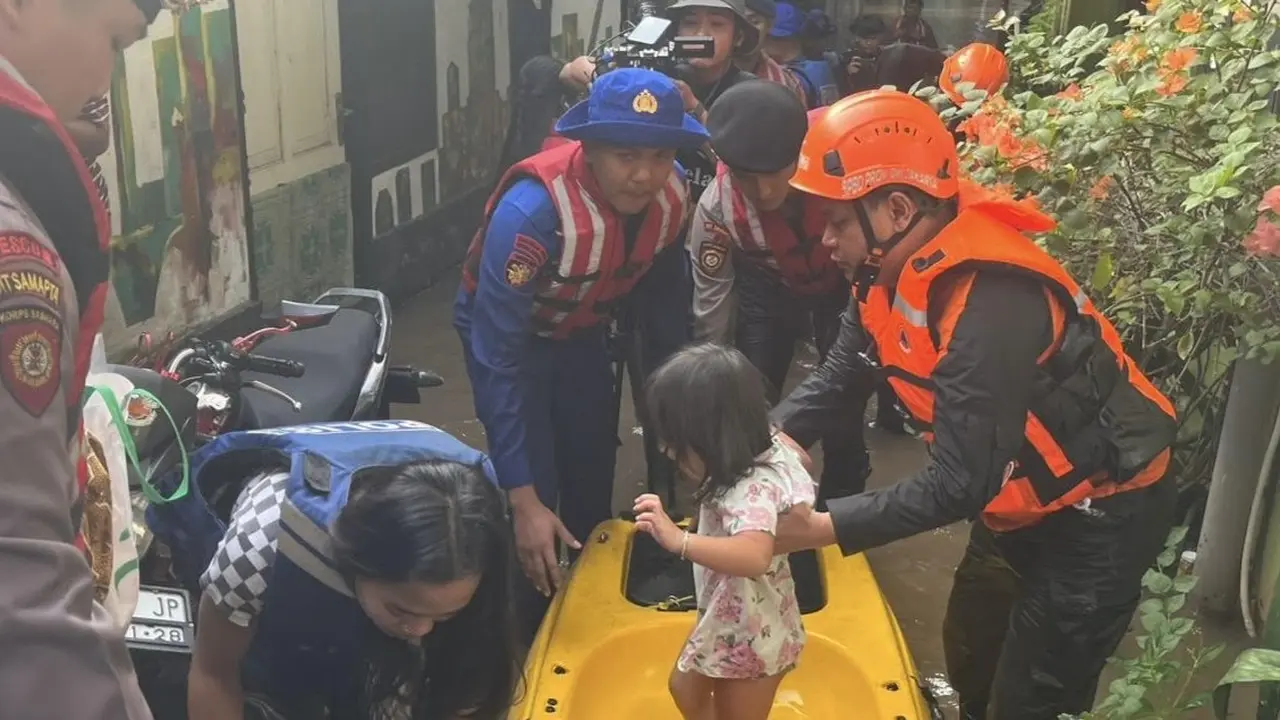 Polisi turun tangan untuk membantu evakuasi warga yang terdampak banjir di Kebon Pala, Kampung Melayu, Jatinegara, Jakarta Timur.