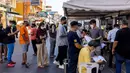 Pekerja perhotelan dan pariwisata mengantre untuk tes virus corona COVID-19 di Jalan Khao San, Bangkok, Thailand, Kamis (6/1/2022). (Jack TAYLOR/AFP)