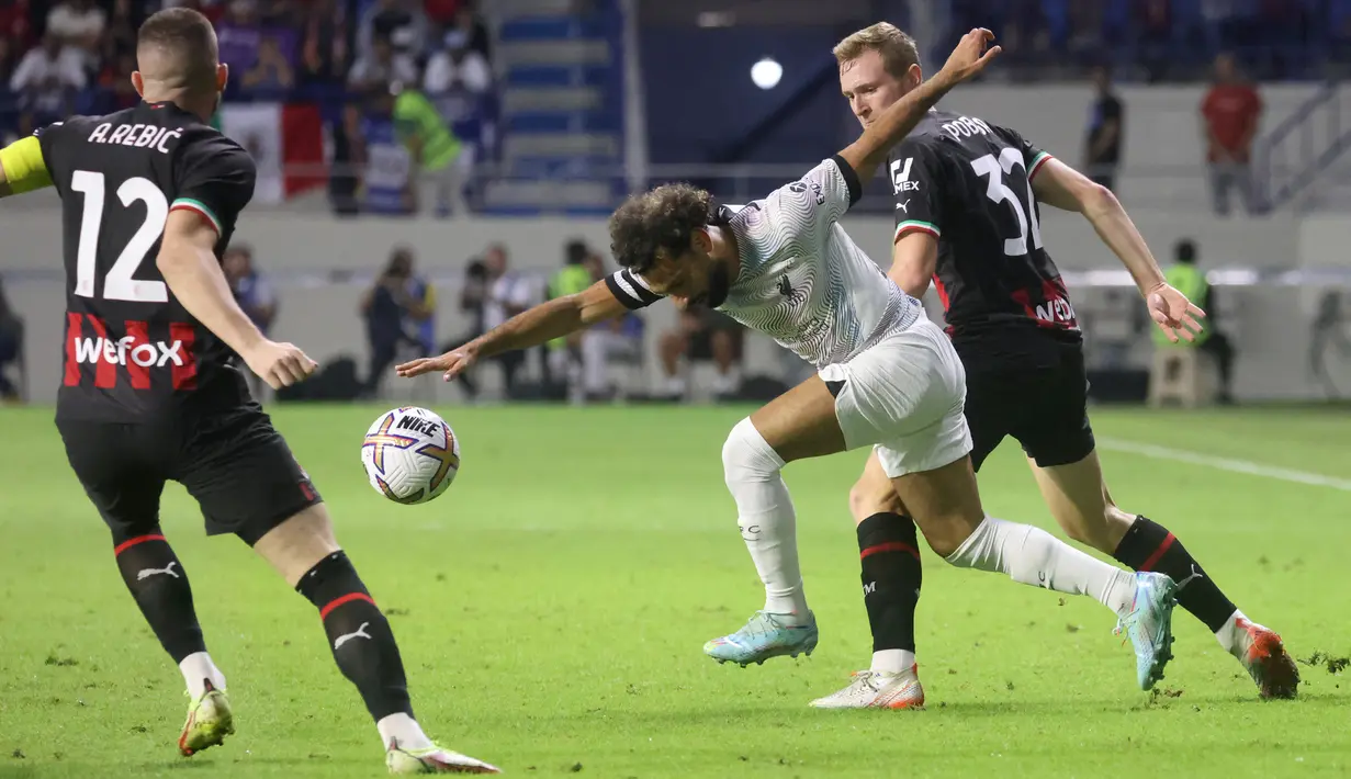 Penyerang Liverpool, Mohamed Salah berusaha membawa bola dari kawalan pemain AC Milan, Ante Rebic dan Tommaso Pobega selama pertandingan  Dubai Super Cup 2022 di stadion al-Maktoum, Uni Emirat Arab, Jumat (16/12/2022). Liverpool menang telak atas AC Milan 4-1. (AFP/Karim Sahib)