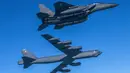 Pesawat Stratofortress B-52H Angkatan Udara Amerika Serikat (bawah) terbang dalam formasi dengan pesawat tempur F-15K Angkatan Udara Korea Selatan di atas laut barat Semenanjung Korea saat latihan udara bersama di Korea Selatan, Senin (6/3/2023). Korea Utara menilai latihan militer Amerika Serikat dan Korea Selatan telah meningkatkan ketegangan yang mengancam pihak-pihak tertentu bisa lepas kendali. (South Korea Defense Ministry via AP)