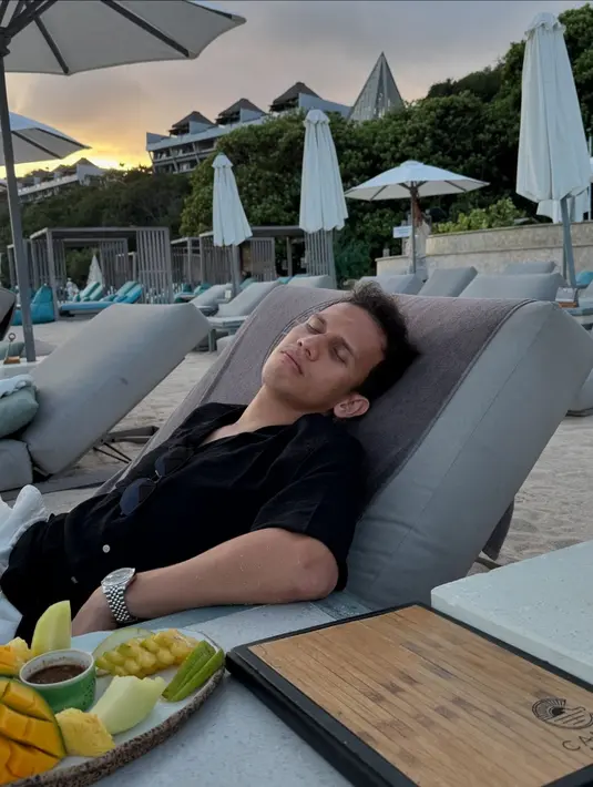 Rebahan di day bed, Egy terlihat dengan kacamata hitam tergantung di kemeja dan kenakan jam tangan [@adiba.knza]