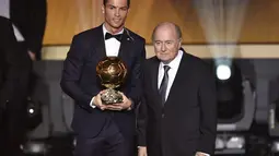 Penyerang Real Madrid Cristiano Ronaldo didampingi Presiden FIFA saat meraih penghargaan Ballon d'Or 2014 di Swiss, Senin (12/1/2015). (AFP PHOTO/Fabrice COFFRINI)