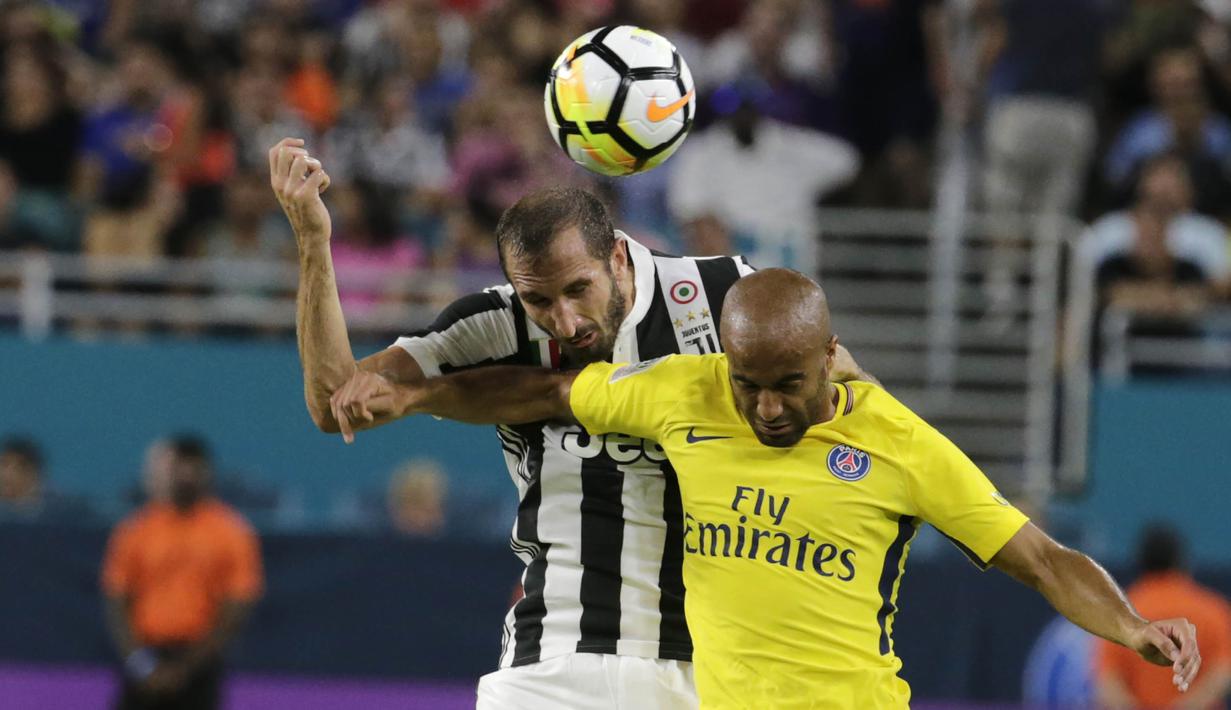 Bek Juventus, Giorgio Chiellini, duel udara dengan gelandang Paris St Germain, Lucas Moura, pada laga ICC di Stadion Hard Rock, Florida, Rabu (26/7/2017). Juventus menang 3-2 atas PSG. (AP/Lynne Sladky)