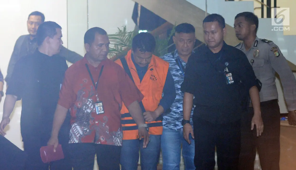 Bupati Jombang Nyono Suharli Wihandoko (tengah) usai menjalani pemeriksaan pasca terkena OTT di Gedung KPK, Jakarta, Minggu (4/2). Nyono menjadi tersangka dalam dugaan suap perizinan pengurusan jabatan di Pemkab Jombang. (Liputan6.com/Helmi Fithriansyah)