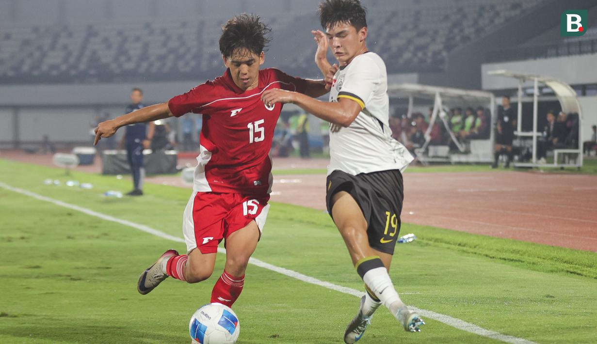 Pemain Timnas Indonesia U-17, Miraj Rizky mencoba mempertahankan bola dari rebutan pemain China U-17, Ailikamu Yilihong dalam pertandingan uji coba internasional di Indomilk Arena, Tangerang, pada Rabu (11/2/2026) malam WIB. (Bola.com/Abdul Aziz)