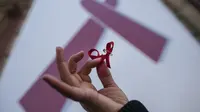 Perempuan memegang simbol pita ketika demo di Hari AIDS Sedunia, Pamplona, Spanyol, Senin (1/12). | via: Alvaro Barrientos/AP Photo