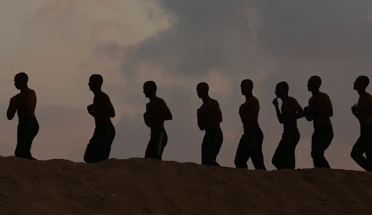Mahasiswa Palestina berlari di atas bukit saat matahari terbenam selama pelatihan militer di Al-Rebat College for Law and Police Science, Khan Younis, Jalur Gaza, Kamis (24/10/2019). Kampus tersebut didirikan oleh pemerintahan Hamas sejak tahun 2009 . (AP Photo/Adel Hana)
