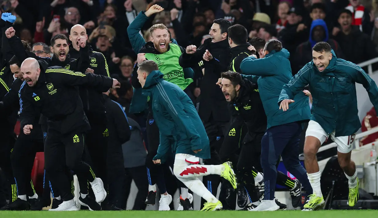 Reaksi bahagia Mikel Arteta, tim pelatih, dan pemain cadangan Arsenal setelah menang atas Porto pada babak adu penalti saat laga leg kedua 16 besar Liga Champions 2023/2024 di Emirates Stadium, London, Inggris, Rabu (13/03/2024). (AFP/Adrian Dennis)