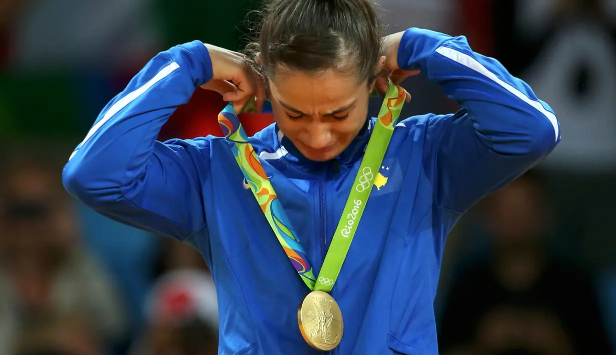 Atlet Kosovo, Majlinda Kelmendi  menyeka air mata bahagianya setelah meraih emas pada cabang judo putri Olimpiade 2016 di Rio de Janeiro, Minggu (7/8). Kelmendi menjadi atlet pertama dari Kosovo yang meraih medali Olimpiade. (REUTERS/Toru Hanai)