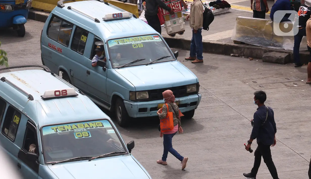 Warga berjalan di antara angkot yang menunggu di kawasan Stasiun Tanah Abang, Jakarta, Kamis (7/1/2021). Pemerintah akan melakukan pembatasan kapasitas dan operasional transportasi umum seiring diterapkannya kebijakan Pembatasan Kegiatan Masyarakat (PKM) di Jawa dan Bali. (Liputan6.com/Angga Yuniar)