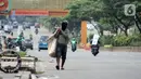 Pemulung berjalan di Jalan Margonda Raya, Depok, Kamis (16/4/2020). Pandemi COVID-19 memberikan dampak yang sangat besar bagi sosial dan ekonomi Indonesia. Bahkan yang paling dikhawatirkan bertambahnya angka kemiskinan dan pengangguran. (Liputan6.com/Helmi Fithriansyah)