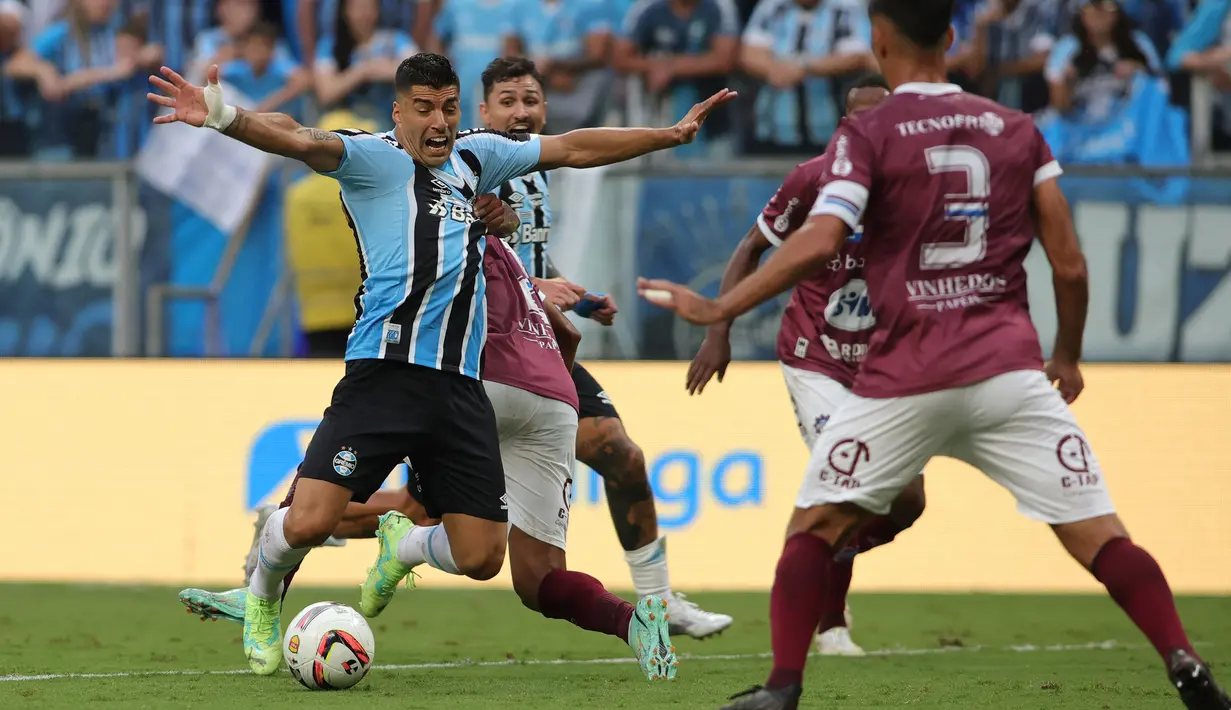 Pemain Gremio, Luis Suarez berebut bola dengan pemain Caxias pada leg kedua final Gaucho Championship di Arena do Gremio Stadium, Porto Alegre, Brasil, 8 April 2023. Gol kemenangan Gremio dicetak oleh Luis Surez melalui tendangan penalti pada menit ke-65. (AFP/Silvio Avila)