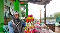 Nuryana, nenek berusia 80 tahun yang masih semangat berjualan kembang kuburan di TPU Kandang Kawat Palembang, kendati di bualn Ramadan sepi pelayat yang datang (Liputan6.com / Nefri Inge)