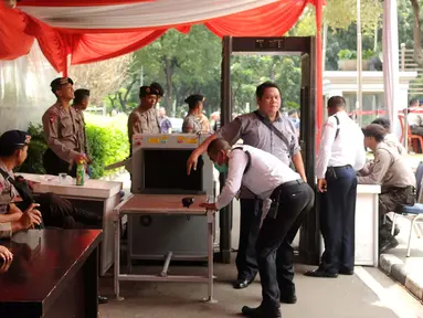 Petugas keamanan melakukan pemeriksaan tubuh pada pengunjung yang akan mengikuti sidang pembacaan putusan perselisihan hasil Pilkada 2015 di gedung Mahkamah Konstitusi, Jakarta, Senin (18/1/2016). (Liputan6.com/Helmi Fithriansyah)