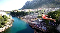 Peserta pria beraksi dengan melompat dari jembatan saat mengkuti acara kompetisi menyelam tradisional 450 di Mostar, Bosnia dan Herzegovina, (31/7). (REUTERS/Dado Ruvic)